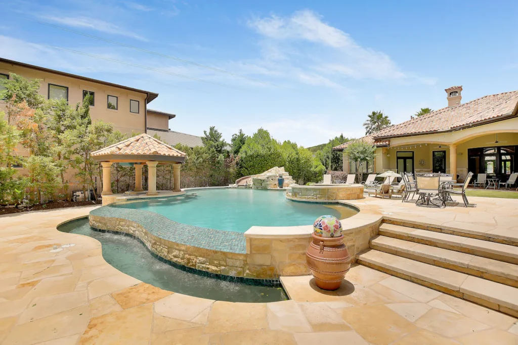 Luxury vacation rental in Lake Austin with slide-equipped waterfront pool.